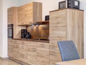 ロディンにあるHaus Achterwasserblick FeWo 4の木製のキャビネットとカウンタートップを備えたキッチン