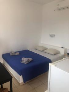 a bedroom with a bed with blue sheets and pillows at Mylopota Studio II in Mylopotas