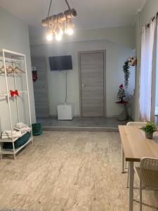 un soggiorno con TV, tavolo e sedie di Neapolis center2 a Napoli