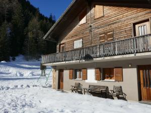 a building with tables and chairs in the snow at Apartment Prou Riverside by Interhome in Campo Blenio