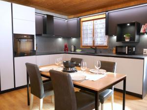 a kitchen with a wooden dining table and chairs at Apartment Prou Forestside by Interhome in Campo Blenio +26 photos