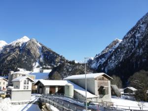 a building in the snow with mountains in the background at Apartment Prou Forestside by Interhome in Campo Blenio