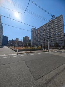 Una calle vacía en una ciudad con un edificio alto. en SuYi, en Osaka
