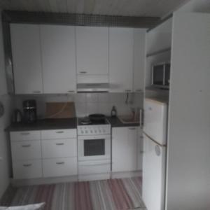 a kitchen with white cabinets and a white refrigerator at Perniön majoitus Huoneisto a4 in Perniö