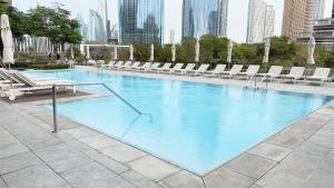 a large swimming pool with lounge chairs and a city at Ultimate Stay Luxurious Address Opera 2BR Next to Burj Khalifa and Dubai Mall Large Balcony with Stunning Views in Dubai
