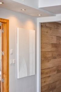 un espejo en una pared junto a una puerta de madera en Apartamento con Terraza, Piscina y Parking By Aloha Palma, en Águilas