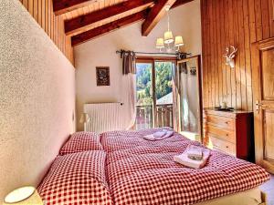 a bedroom with a bed with a red and white checkered blanket at Chalet Le Coeur by Interhome in Ovronnaz