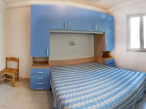 een slaapkamer met een bed met blauwe kasten en een stoel bij Holiday Home Villaggio San Pablo-4 by Interhome in Vieste