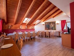 a banquet hall with tables and chairs in a room with wooden ceilings at Apartment Garni Eden by Interhome in Soraga