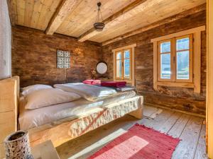 a bed in a room with wooden walls and windows at Holiday Home Margherita by Interhome in Mrkopalj +26 photos