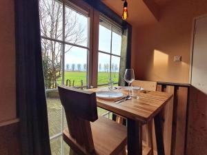 a dining room with a table and a large window at De Rusthut in Wolphaartsdijk