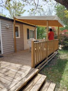 een persoon die op een terras zit met een prieel bij Mobil-home - Le 147 aux Iscles in La Roque-dʼAnthéron