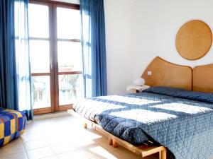 Un dormitorio con una cama y una ventana grande. en Apartment Cosmopolitan Golf - TIR280 by Interhome, en Tirrenia