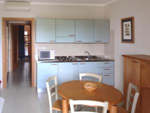cocina con mesa de madera y microondas en Apartment Cosmopolitan Golf - TIR280 by Interhome, en Tirrenia