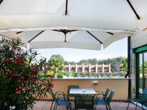 un patio con mesa y sillas bajo una sombrilla blanca en Apartment Cosmopolitan Golf - TIR280 by Interhome, en Tirrenia 11 fotos más