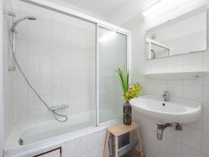 a white bathroom with a sink and a shower at Apartment Sirius with parking and shared pool by Interhome in De Haan