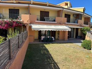 a house with a patio and a white awning at Beautiful Apartment with Swimming Pool in Olbia