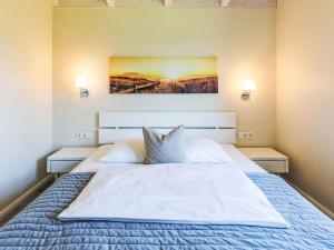Un dormitorio con una gran cama blanca con dos lámparas. en Holiday Home Wolken Blick by Interhome, en Dagebüll
