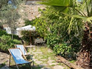 dos sillas y una sombrilla en un jardín en Holiday Home Annina - DOL285 by Interhome, en Bellissimi