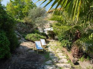 dos sillas de jardín sentadas en un patio con árboles en Holiday Home Annina - DOL285 by Interhome, en Bellissimi