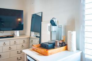 een kamer met een tv en een dressoir met een lamp bij Citrus Queen at Custom House Inn in Key West