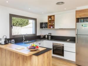 een keuken met witte apparaten en een fruitschaal op een aanrecht bij Holiday Home La Manzaneta by Interhome in Calonge