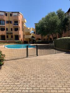 a fence around a swimming pool in a courtyard at Beautiful Apartment with Swimming Pool in Olbia