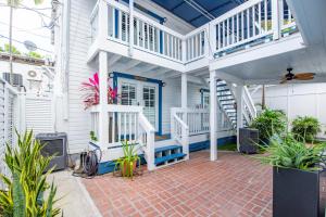 een wit huis met een trap en een patio bij Sunshine State at Custom House Inn in Key West +17 foto's