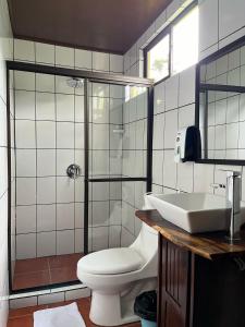 a bathroom with a toilet and a shower and a sink at Hotel y Restaurante El Páramo in San Rafael Norte +21 photos