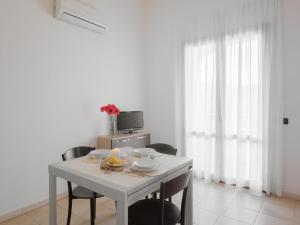 a white table with chairs in a white room at Apartment Le Fontane-4 by Interhome in Villasimius