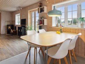 a kitchen and dining room with a wooden table and chairs at Holiday Home Uddi - 1-3km from the sea by Interhome in Fanø