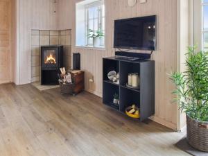 a living room with a television and a fireplace at Holiday Home Uddi - 1-3km from the sea by Interhome in Fanø