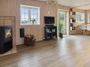 a living room with a fireplace and a television at Holiday Home Uddi - 1-3km from the sea by Interhome in Fanø