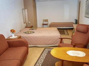 ein Hotelzimmer mit zwei Betten und einer Couch in der Unterkunft Holiday Home Kylpylä-hotelli- room 242 by Interhome in Ikaalinen
