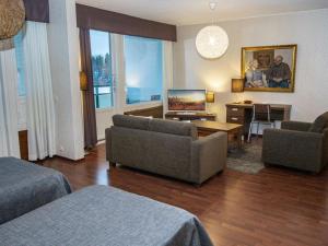 ein Wohnzimmer mit zwei Sofas und einem Fernseher in der Unterkunft Holiday Home Kylpylä-hotelli- kekkosen sviitti- room by Interhome in Ikaalinen