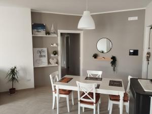 a white dining room with a white table and chairs at Goccia di Mare in Roseto Capo Spulico