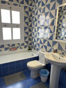 a blue and white bathroom with a toilet and a sink at CozY Condo in Hurghada +7 photos