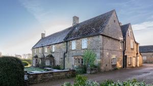 an old stone house with a stone wall at The Sibson Inn Hotel in Water Newton