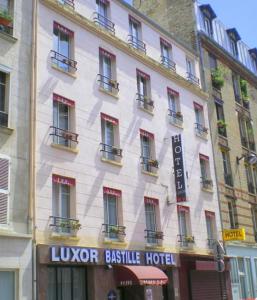 un grand bâtiment blanc avec un panneau d'hôtel dans l'établissement Luxor Bastille Hotel, à Paris