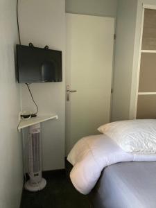 ein Schlafzimmer mit einem Bett und einem Fernseher an der Wand in der Unterkunft Pitchounette villa Canaulaise 3ch 8p in Lacanau
