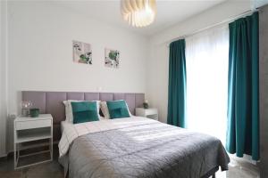 a bedroom with a large bed with green curtains at Aladia Apartment Nikiti in Nikiti