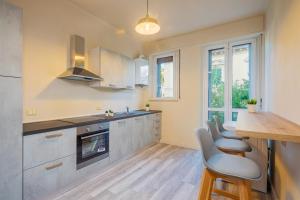 a kitchen with grey cabinets and a table and chairs at Maffi's Apartment - Steps from Pisa Tower in Pisa