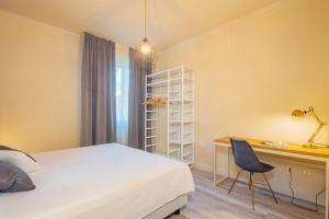a bedroom with a bed and a desk and a chair at Maffi's Apartment - Steps from Pisa Tower in Pisa