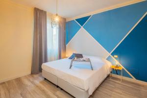 a bedroom with a bed with a blue wall at Maffi's Apartment - Steps from Pisa Tower in Pisa +10 photos