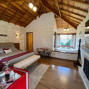 a bedroom with a bed and a tub in a room at Chale Villa do Valle in Monte Verde