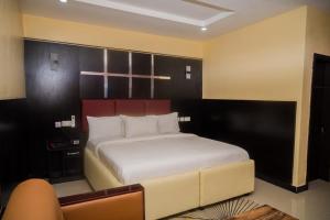 una camera da letto con un grande letto bianco in una stanza di City Base Hotel, Port Harcourt a Port Harcourt