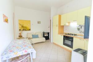 una cucina con un tavolo e un divano in una stanza di Appartamenti Vacanze Roberta a San Vincenzo