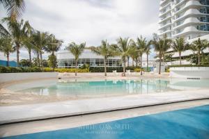 Una piscina con palmeras y un edificio. en Suite - Entire 1BR with Huge Balcony & Mt Arayat View, en San Fernando