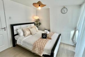 Un dormitorio con una cama con un reloj en la pared. en Suite - Entire 1BR with Huge Balcony & Mt Arayat View, en San Fernando 21 fotos más