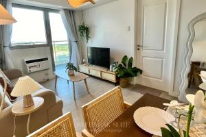 Una sala de estar con un sofá y un televisor. en Suite - Entire 1BR with Huge Balcony & Mt Arayat View, en San Fernando